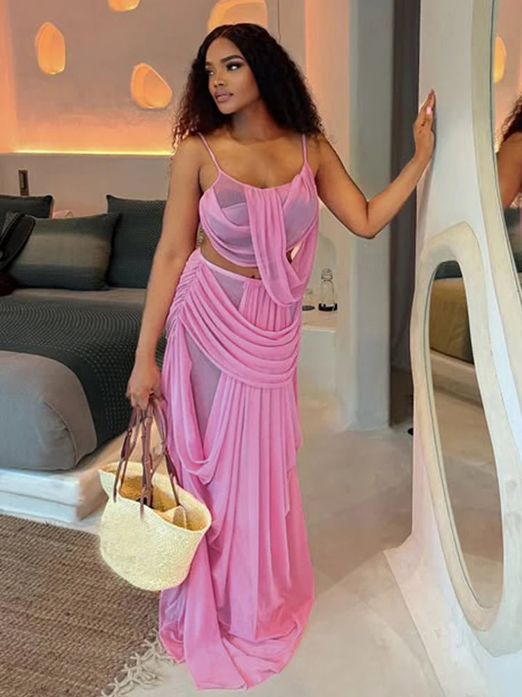 Woman in a pink dress holding a beige bag in an indoor setting