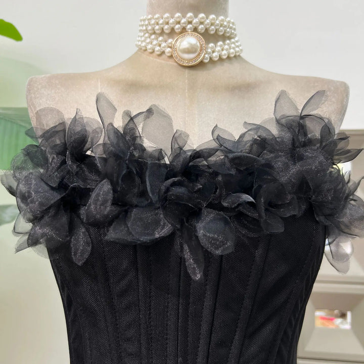Black floral dress on a mannequin with pearl necklace