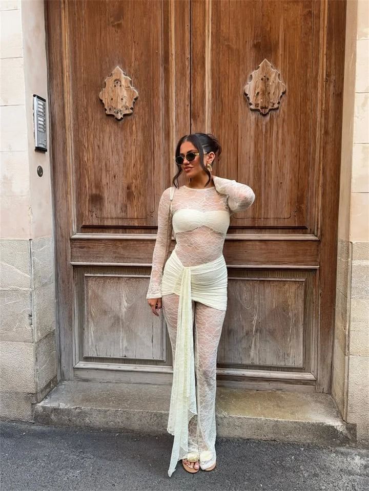 Model wearing a sheer long-sleeve top and pants with a white skirt on a beige background