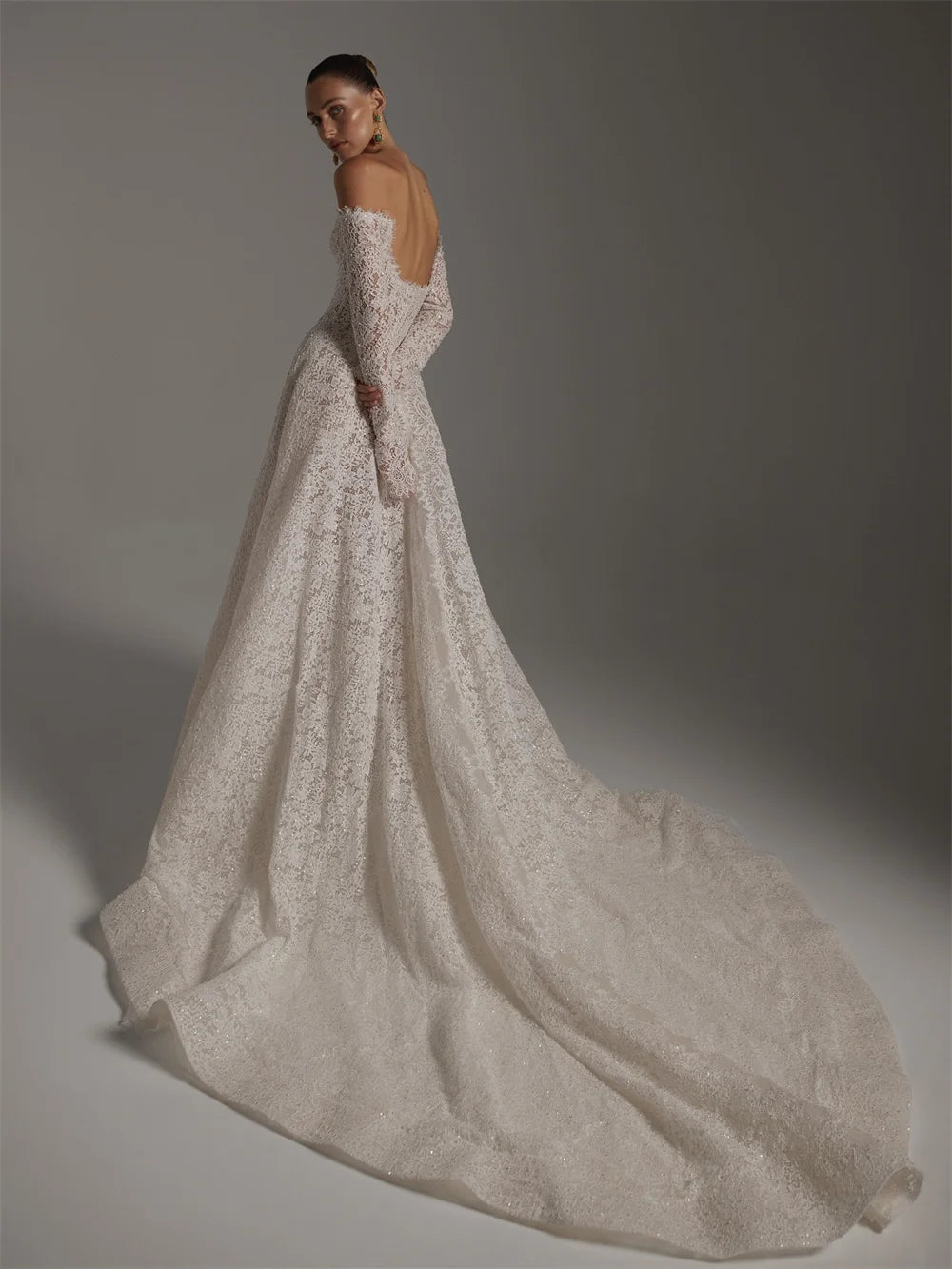 Elegant wedding dress with long train on a plain background