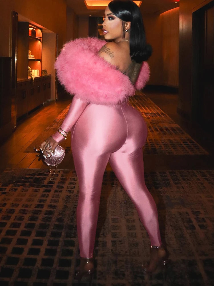 Person wearing a pink outfit with a fluffy pink accessory in an indoor setting