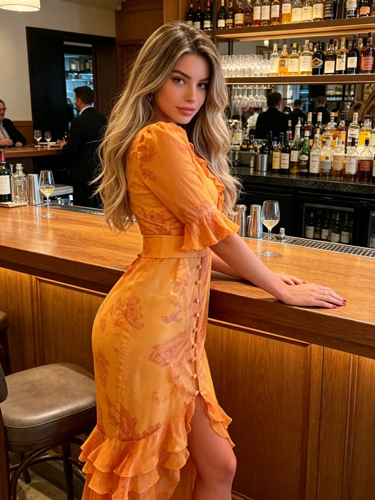 Woman in an orange dress standing at a bar counter with bottles and glasses in the background