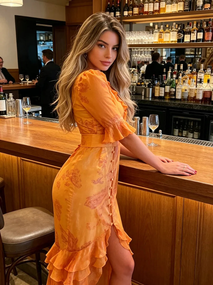 Woman in an orange dress standing at a bar counter with bottles and glasses in the background