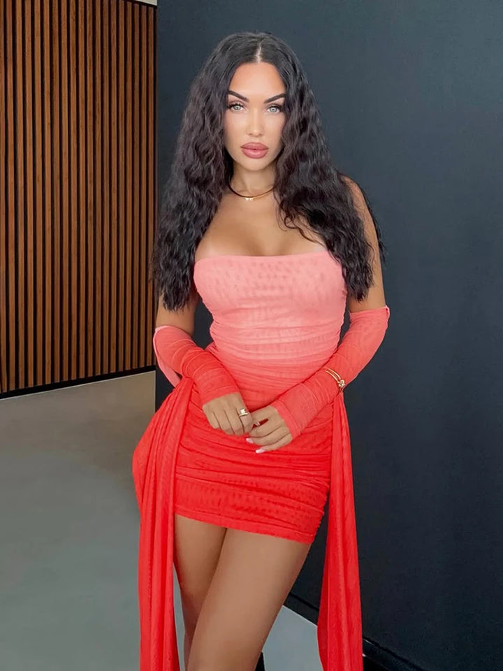 Woman in a red dress with long gloves against a dark wall.