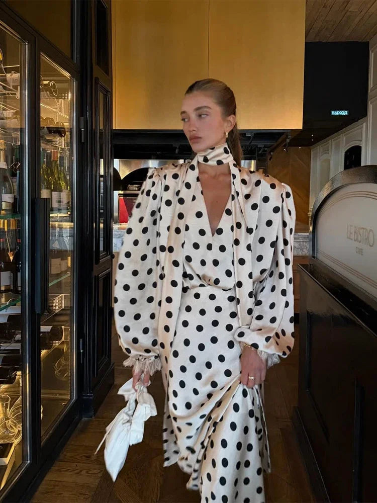 Woman in a polka dot dress standing in a restaurant setting