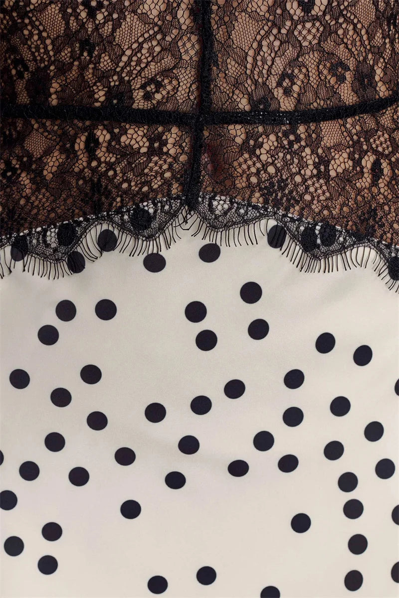 Close-up of black lace overlay on a white fabric with black polka dots