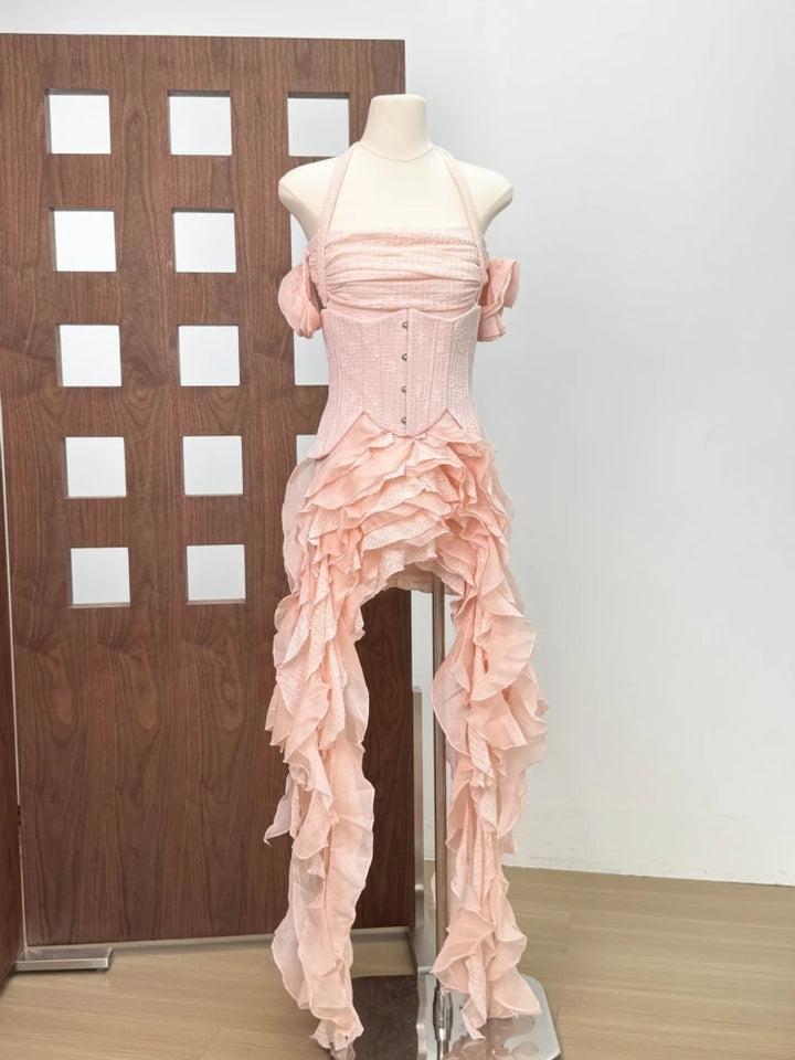 Pink evening gown on a mannequin against a plain wall.