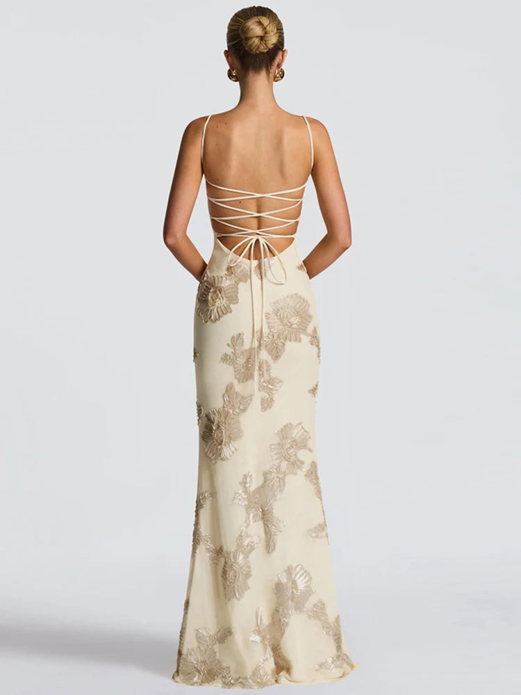 Woman wearing a floral evening gown with a backless design on a white background