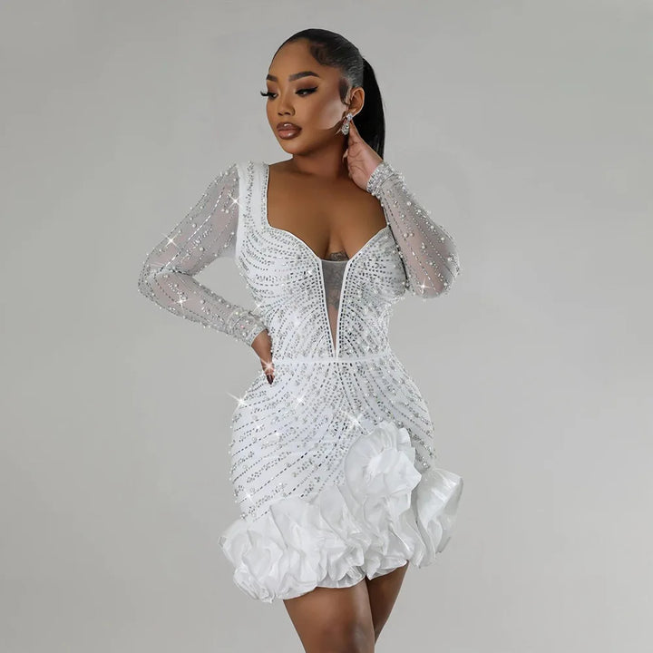 Woman wearing a sparkling white dress against a gray background