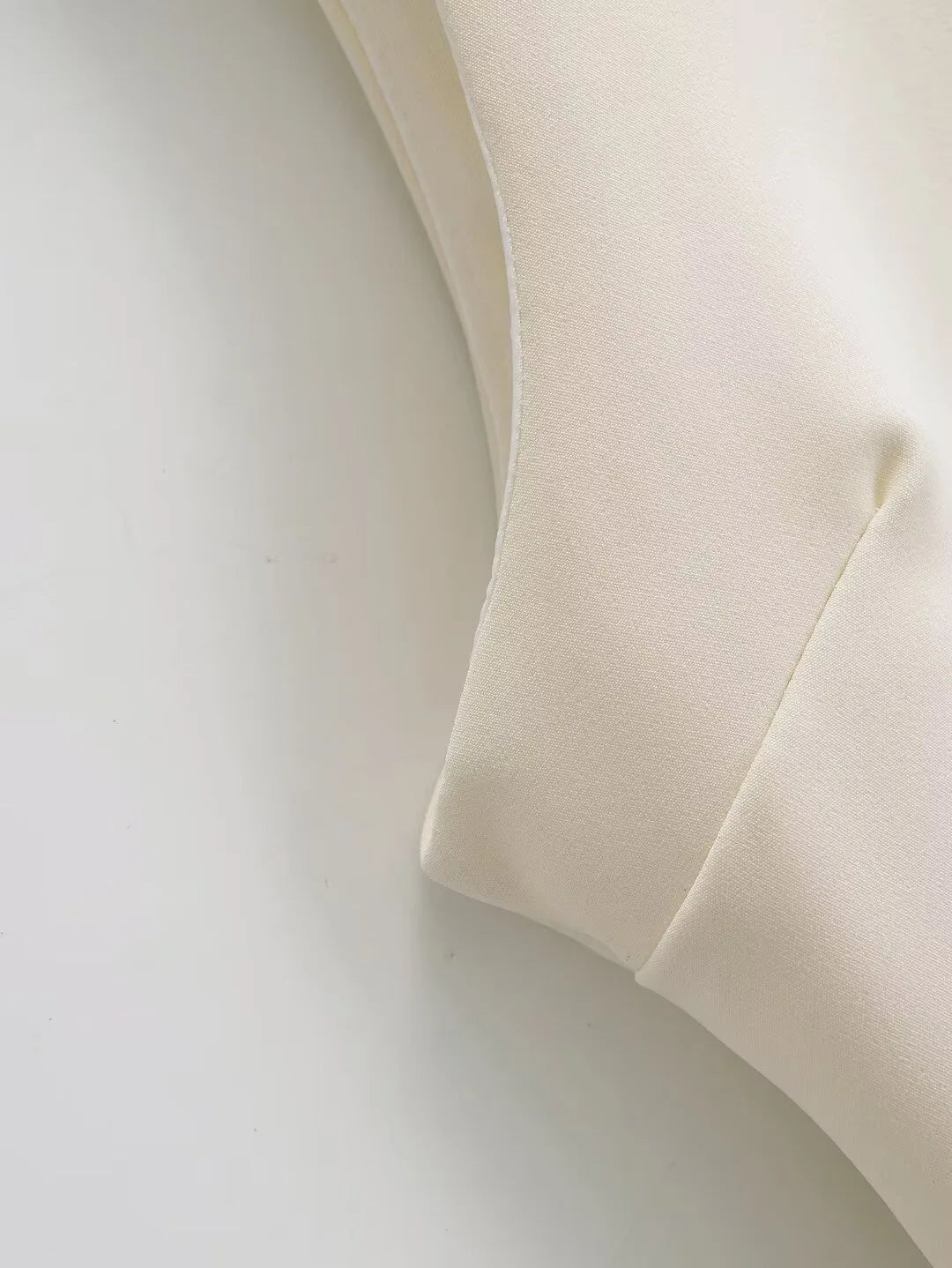 Close-up of a beige fabric texture on a light gray background
