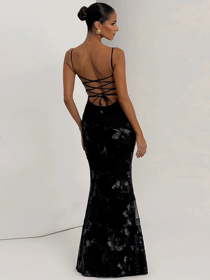 Woman wearing a black lace-up evening gown against a white background