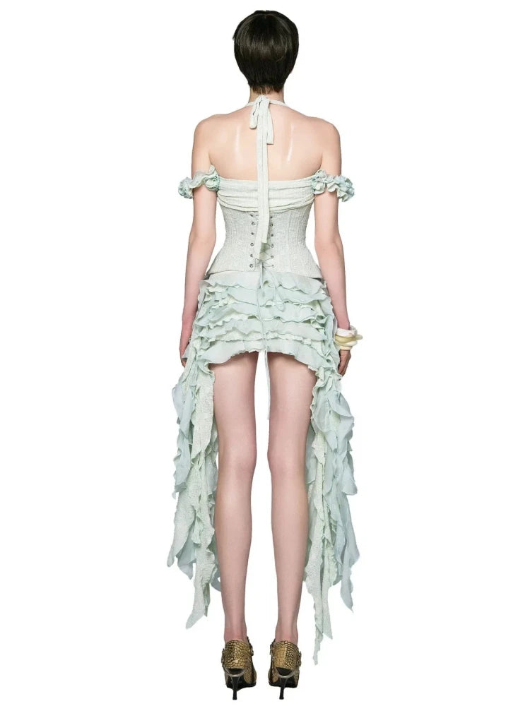 Woman wearing a light green dress with ruffled details on a white background