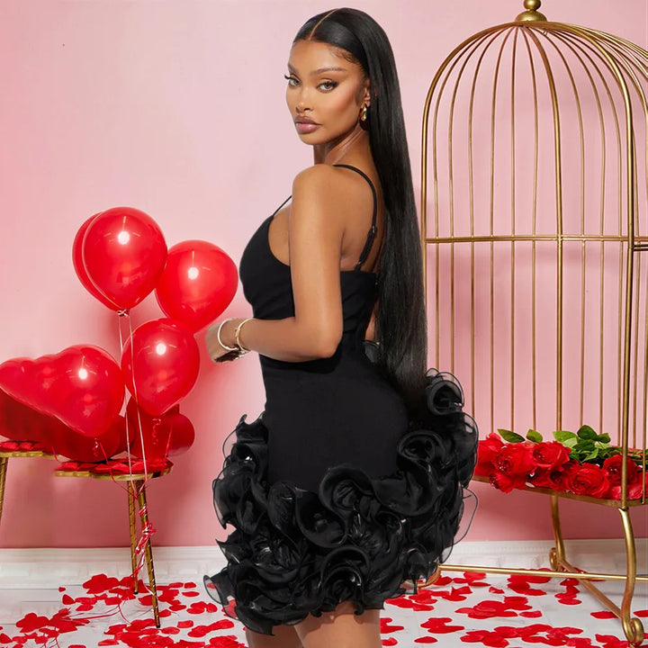 Woman in a black dress with red balloons and roses in a decorative setting