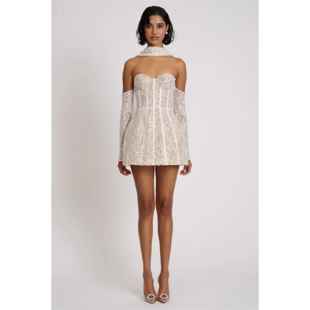 Woman wearing a white lace dress with thin straps on a plain background