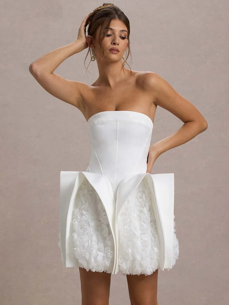 Woman wearing a white strapless dress with floral details on a beige background