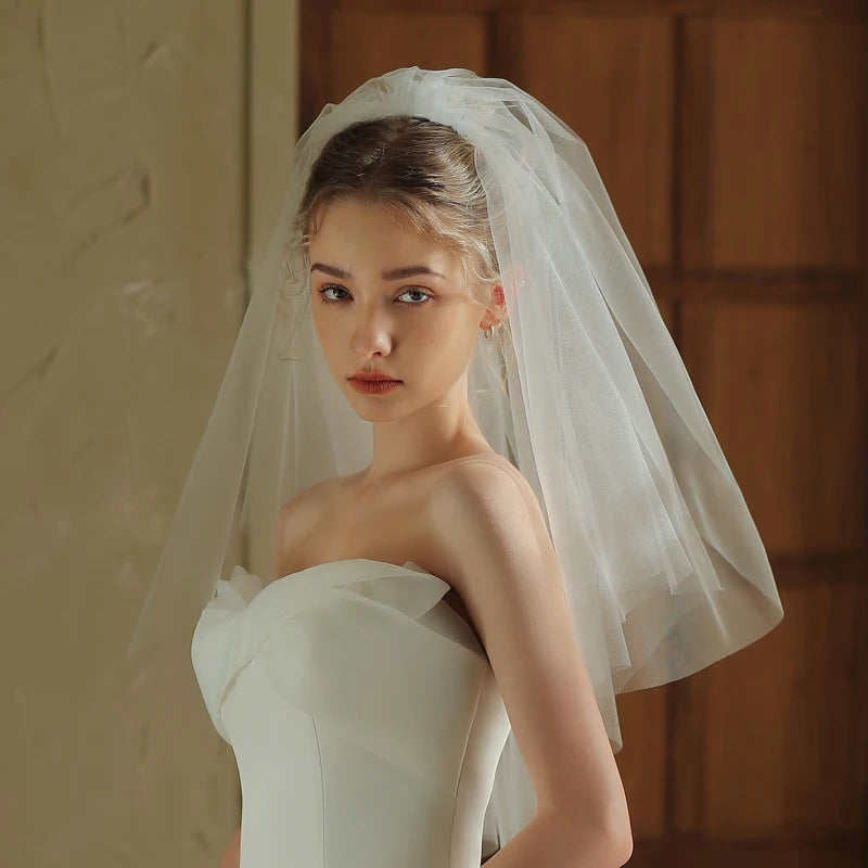 Woman wearing a white wedding dress and veil indoors