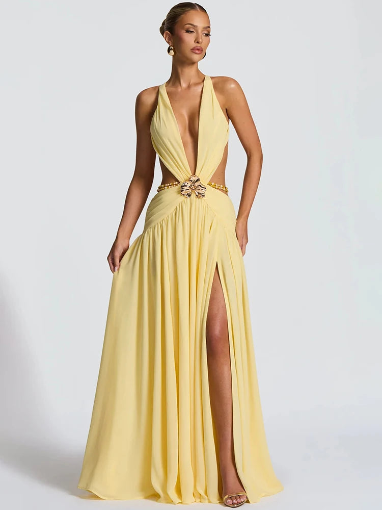 Woman wearing a yellow evening gown with a plunging neckline and high slit on a white background