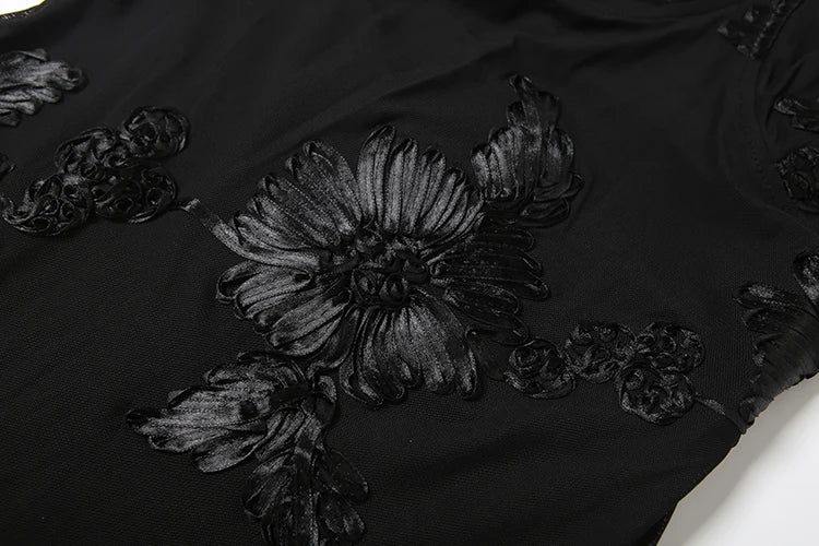 Black floral embroidery on a black fabric background