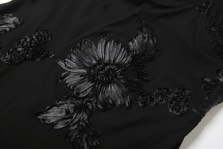 Black floral embroidery on a black fabric background