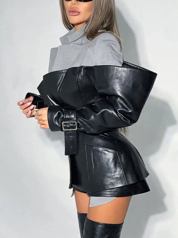 Person wearing a black leather outfit with a gray shirt on a white background