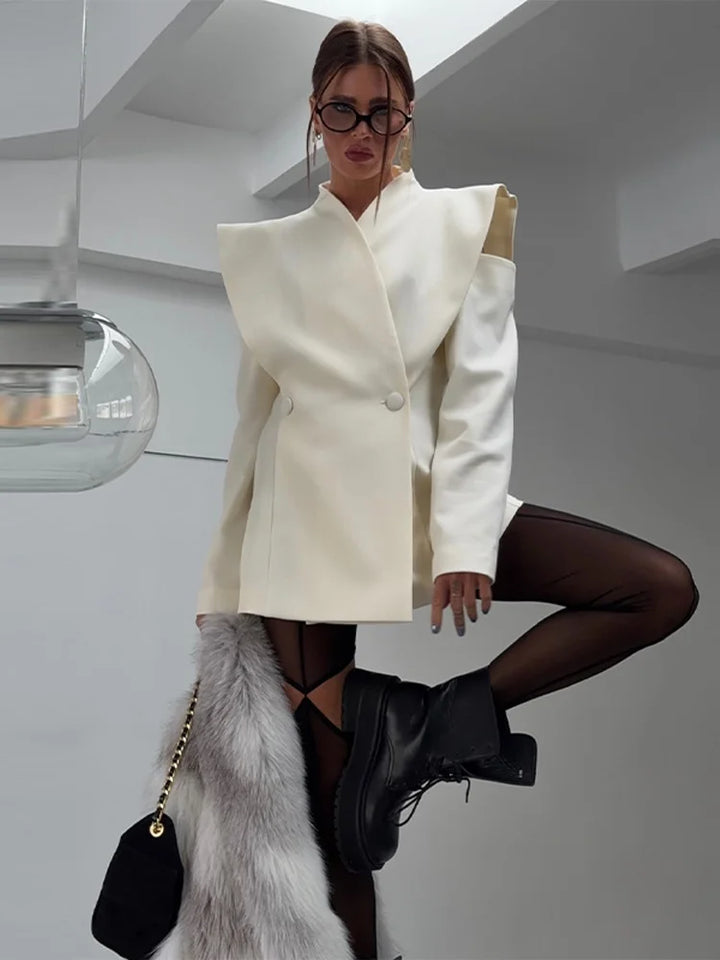 Woman wearing a white coat and black shoes in a modern indoor setting