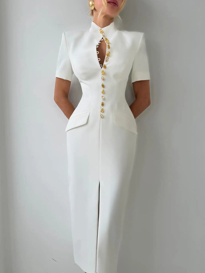 White dress with gold buttons on a plain background