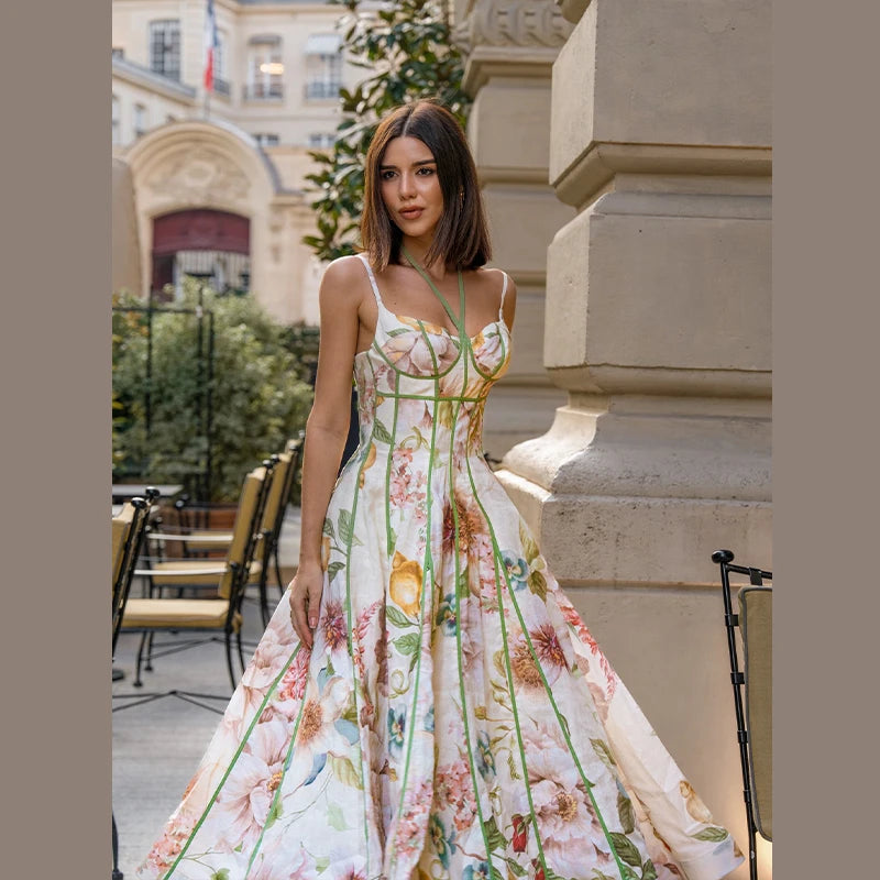 Woman in a floral dress standing outdoors with classical architecture in the background