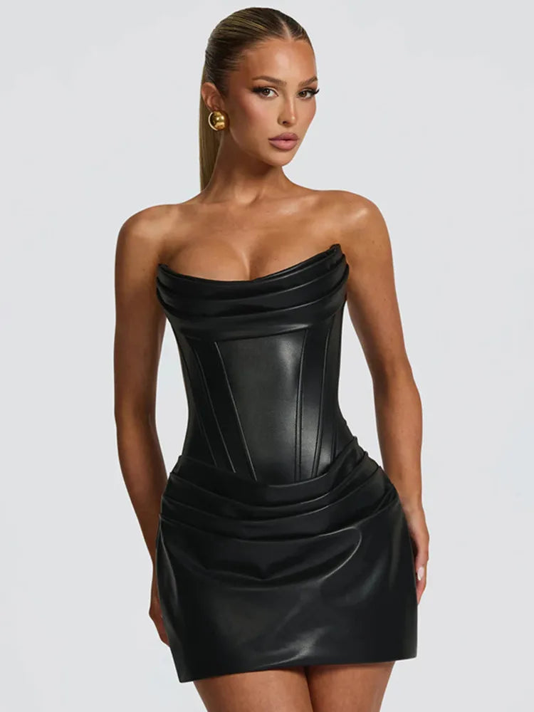 Woman wearing a black strapless dress against a plain background