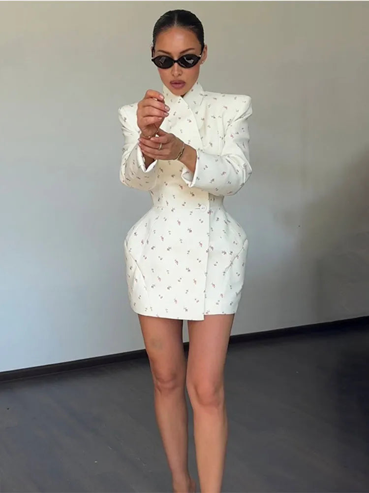 Woman wearing a white dress with ruffled sleeves against a plain background