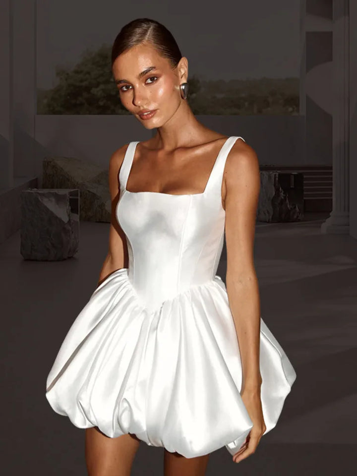 White satin dress worn by a model with a blurred background
