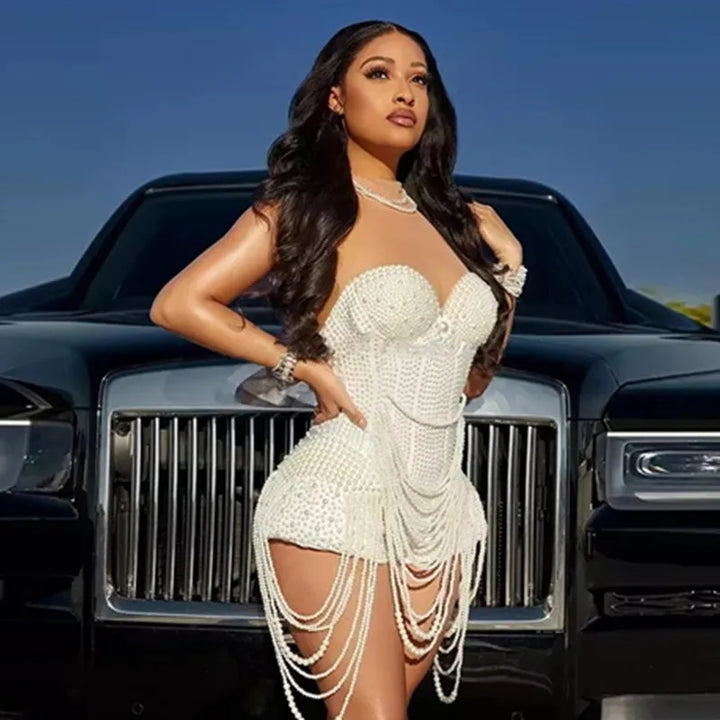 Woman in a white dress standing in front of a black luxury vehicle