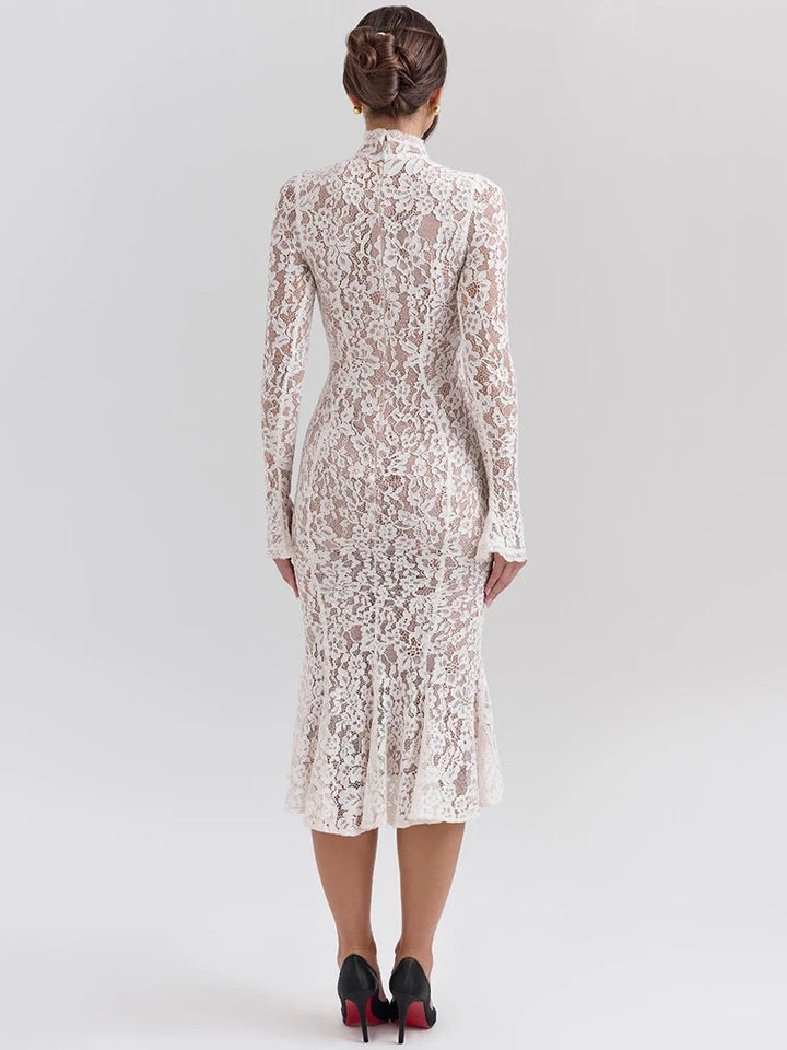 Woman wearing a white lace dress against a gray background