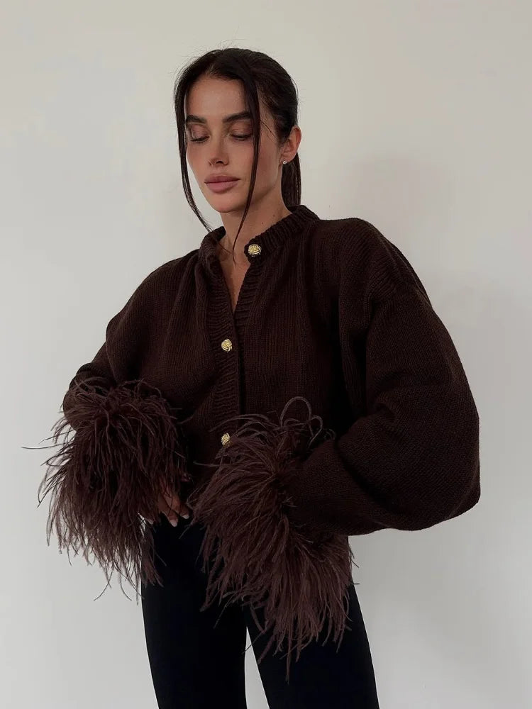 Person wearing a brown feathered garment against a plain background