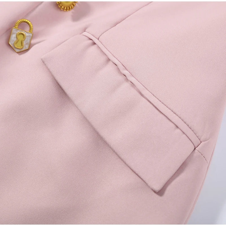 Close-up of a pink fabric with a gold button and decorative element.