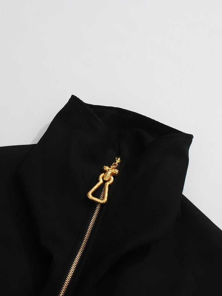 Black jacket with a gold zipper and heart-shaped clasp on a light gray background