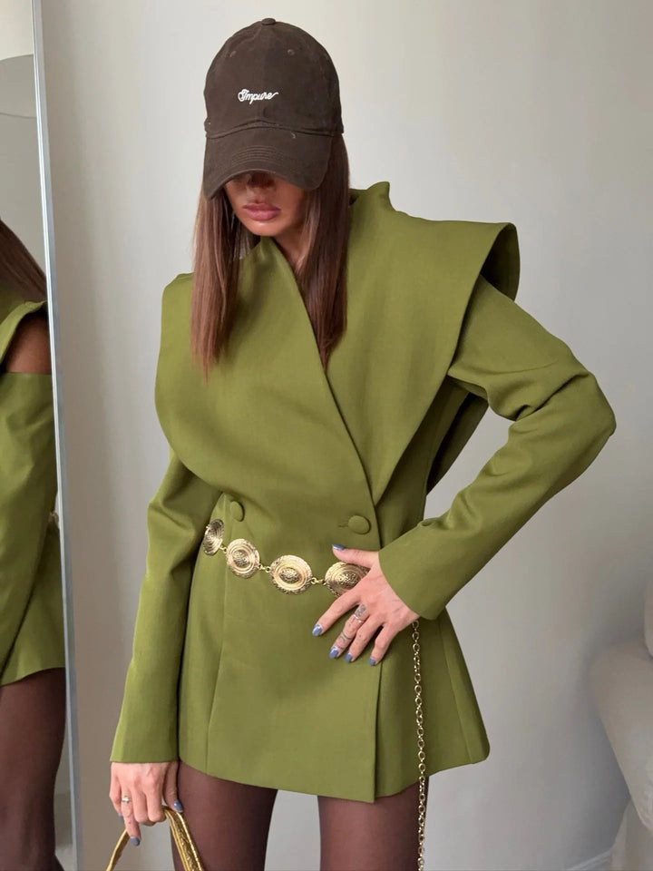 Person wearing a green coat and brown cap indoors