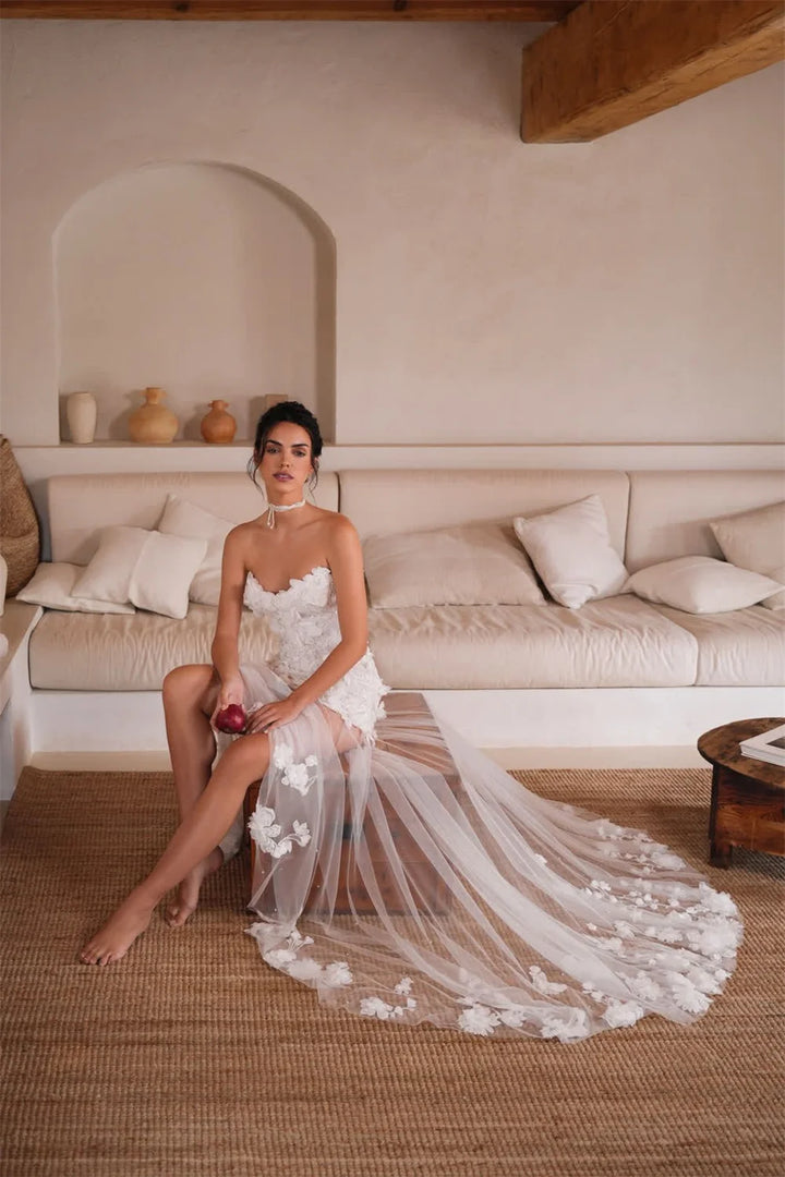 Woman in a white dress sitting on a couch in a cozy living room.