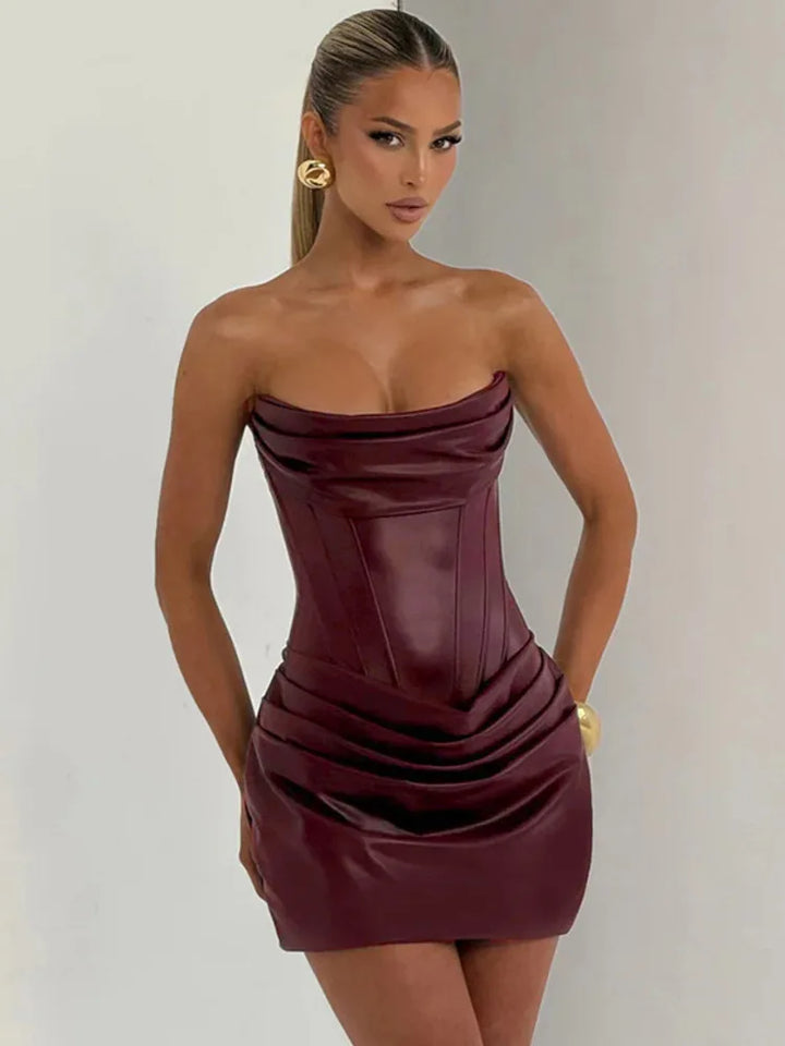 Woman wearing a strapless burgundy dress against a plain background