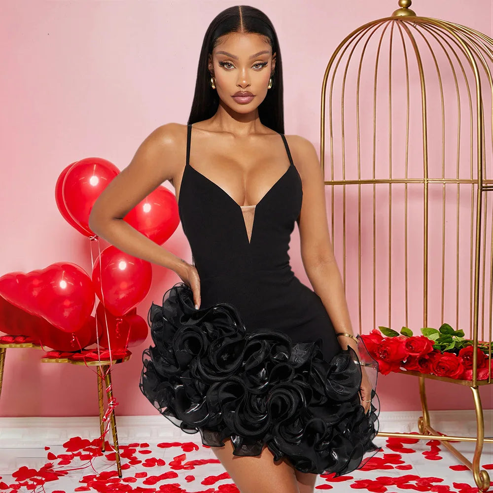 Woman in a black dress holding a black rose clutch with red balloons and roses in the background.