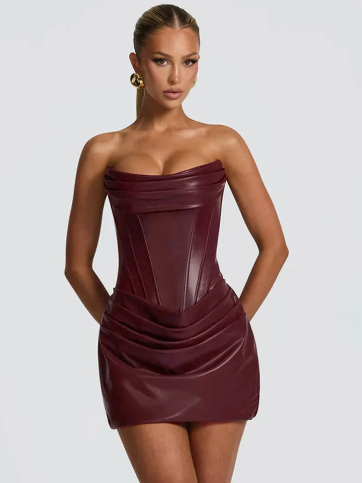 Woman wearing a strapless burgundy dress against a plain background