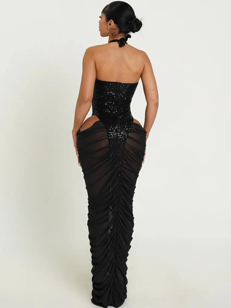 Black strapless gown with sequin detailing and a slit on a white background