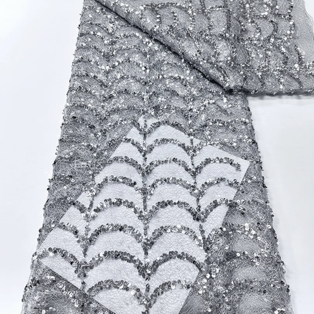 Silver glittery fabric with wavy pattern on a white background