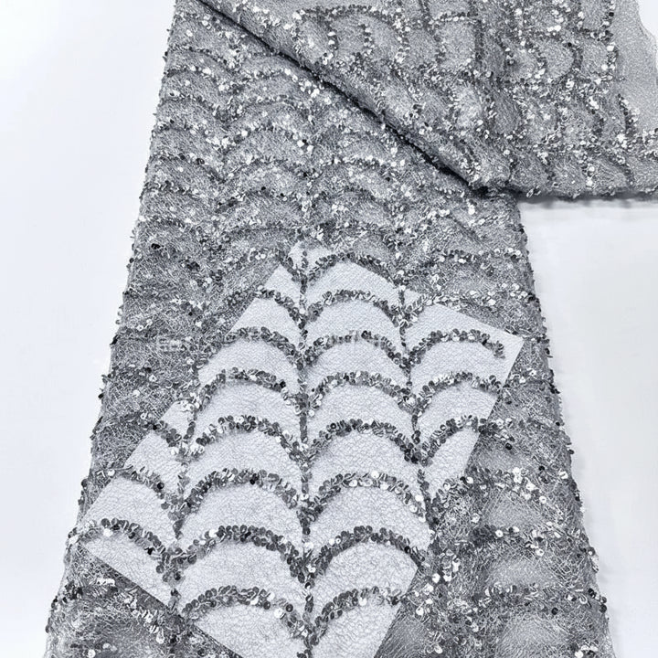 Silver glittery fabric with wavy pattern on a white background