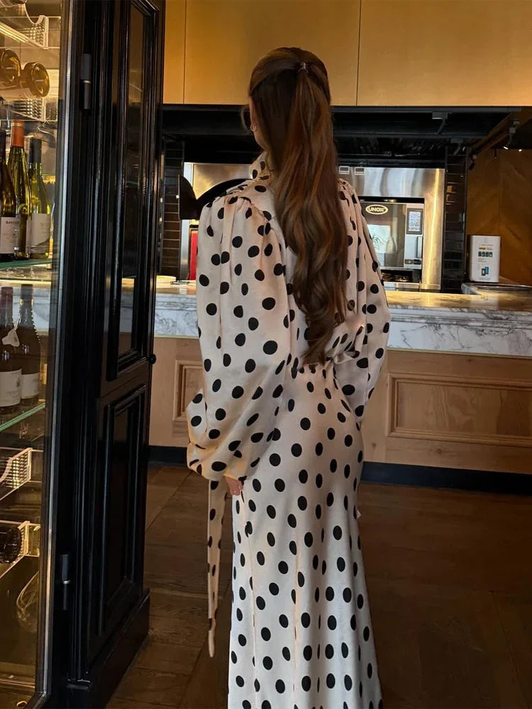 Woman in a polka dot dress standing in a kitchen.
