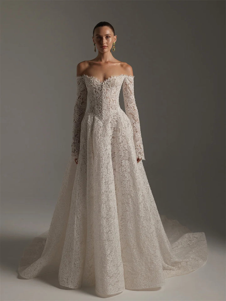 Woman wearing a white lace wedding dress against a gray background