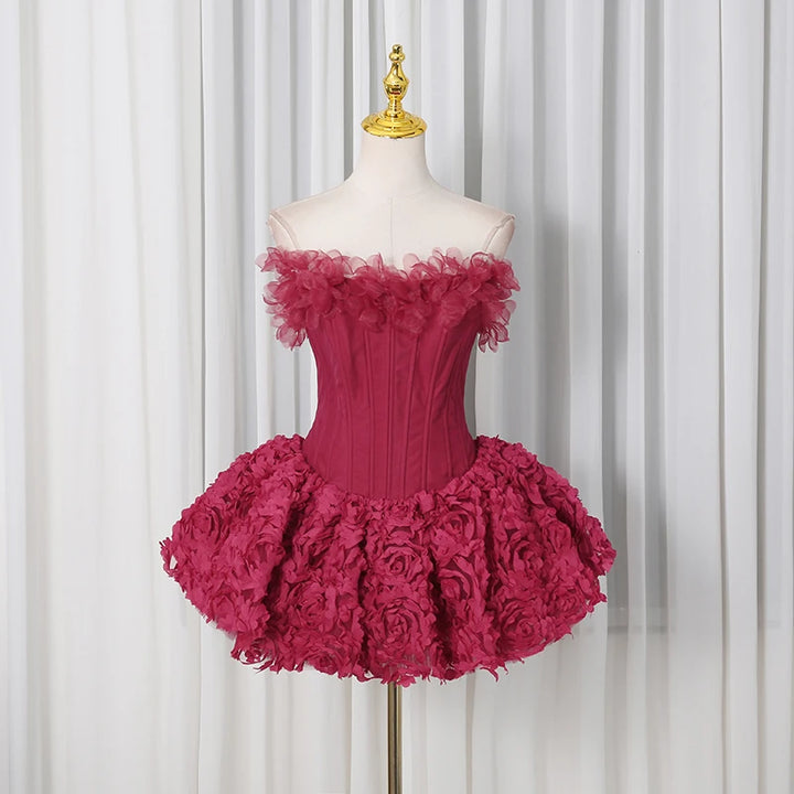 Pink off-shoulder dress with floral details on a mannequin against a white curtain background
