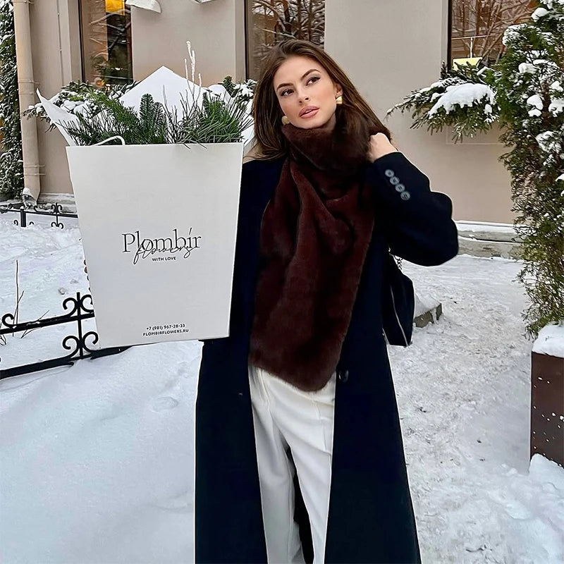 Woman holding a shopping bag with 'Plombir' branding in a snowy outdoor setting