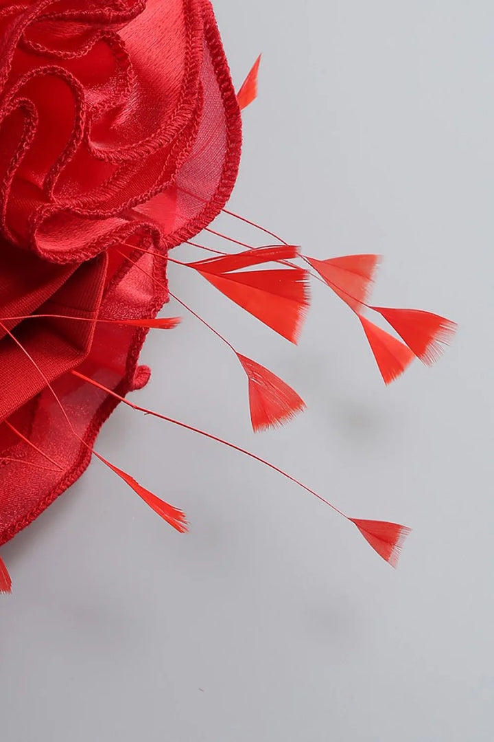 Red decorative flower with long thin petals on a light gray background
